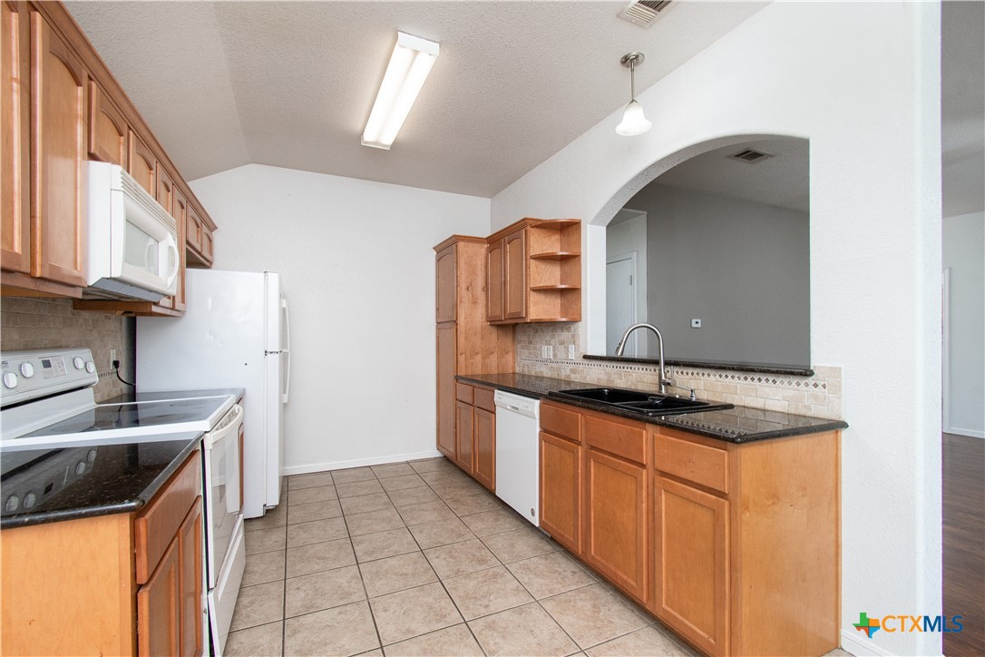 568 Morgan's Point Road Belton, TX 76513 - Photo 9 of 20 a kitchen with granite countertop a sink stove and cabinets