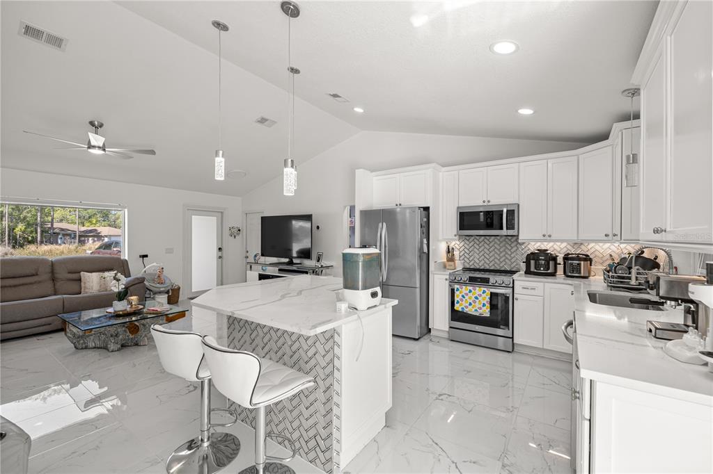 7191 Hemlock Road Ocala, FL 34472 - Photo 12 of 34 a kitchen with stainless steel appliances kitchen island granite countertop a sink and cabinets