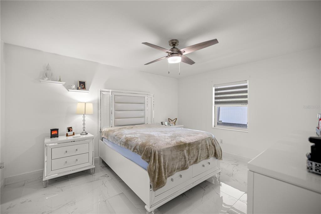 7191 Hemlock Road Ocala, FL 34472 - Photo 15 of 34 a bedroom with a bed and a chandelier