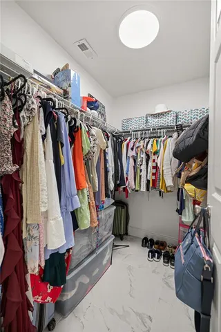 a view of walk in closet with clothes and shoes