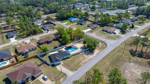 an aerial view of a house with a garden and lake view