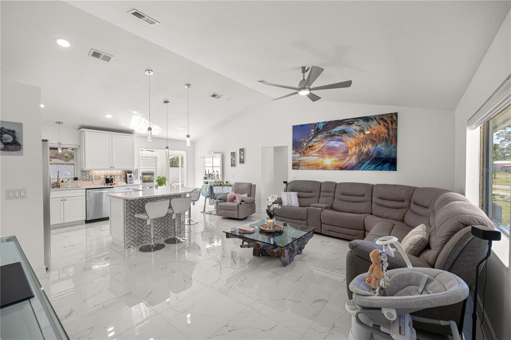 7191 Hemlock Road Ocala, FL 34472 - Photo 9 of 34 a living room with furniture kitchen view and a chandelier