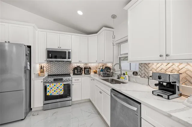 a kitchen with granite countertop a sink stove and refrigerator