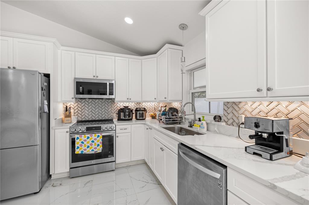 7191 Hemlock Road Ocala, FL 34472 - Photo 10 of 34 a kitchen with granite countertop a sink stove and refrigerator