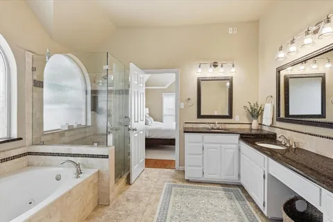 a spacious bathroom with a granite countertop sink and a mirror