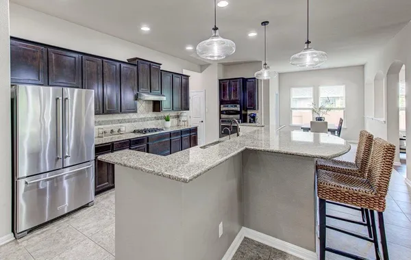 a kitchen with kitchen island a large counter top space appliances and cabinets
