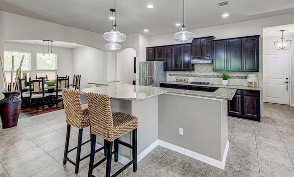 a large kitchen with a table and chairs in it