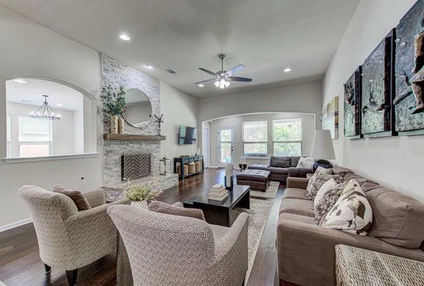 a living room with fireplace furniture and a large window