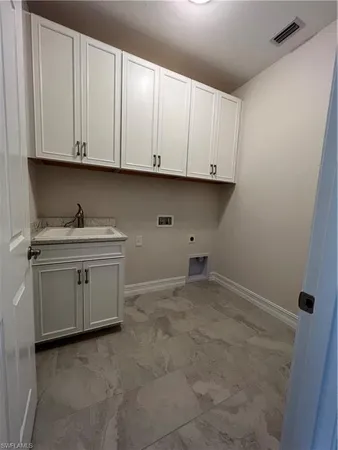 a kitchen with white cabinets and sink