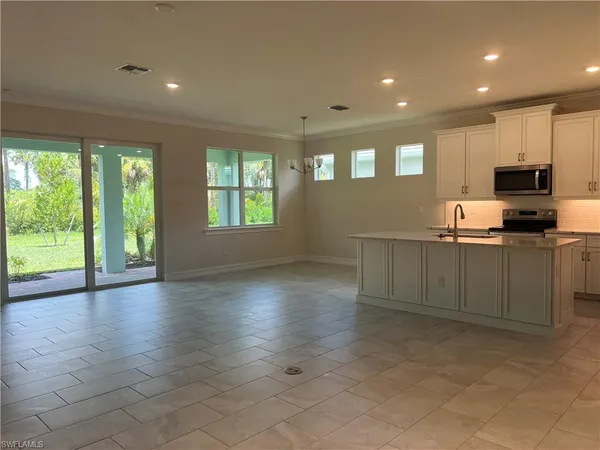 a kitchen with granite countertop a stove a sink and a refrigerator
