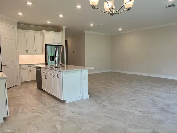 a view of a kitchen with sink microwave and cabinets