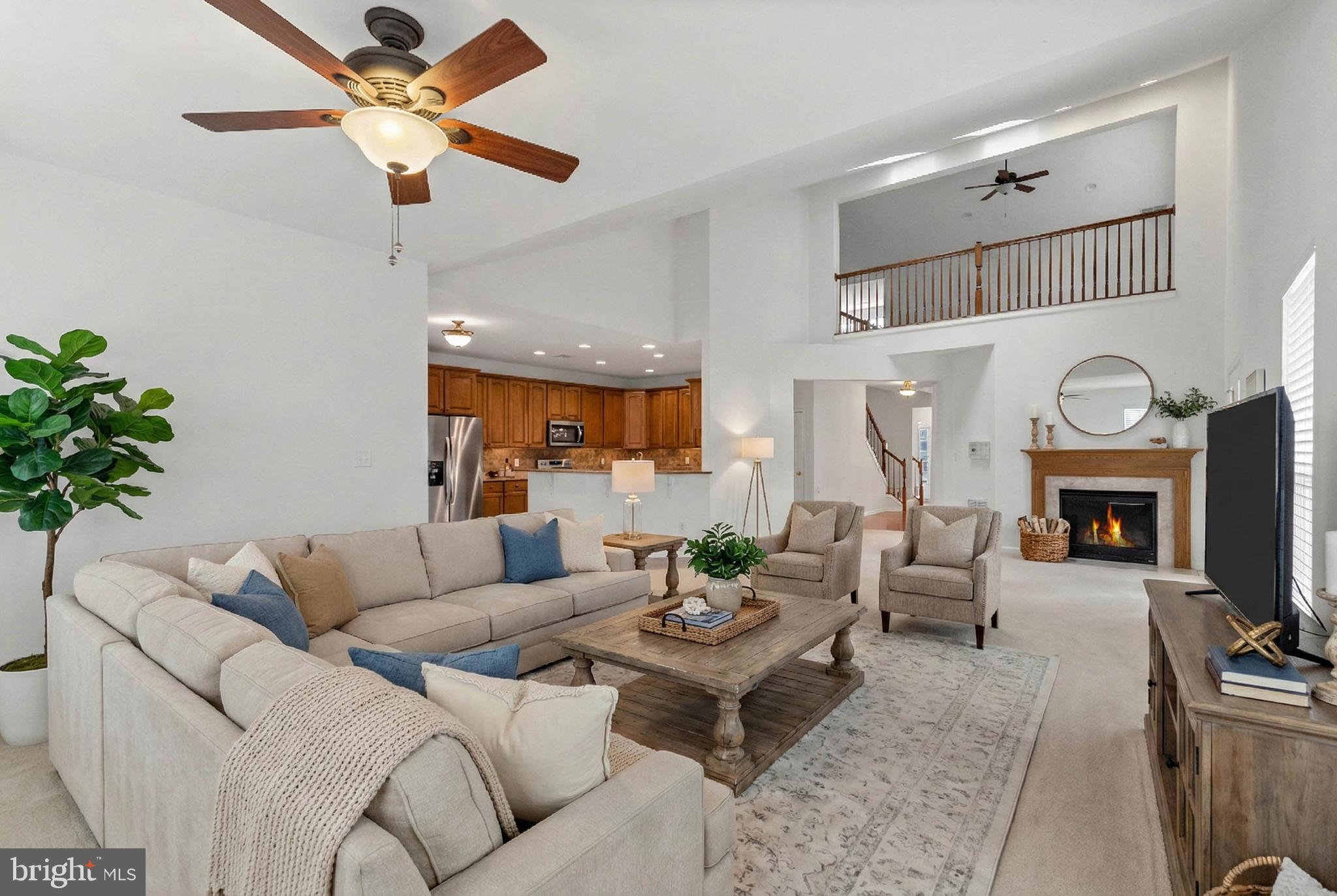 24872 Rivers Edge Road Millsboro, DE 19966 - Photo 12 of 80 a living room with furniture a fireplace and a ceiling fan