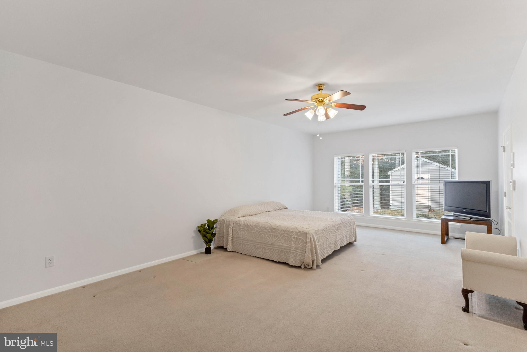 24872 Rivers Edge Road Millsboro, DE 19966 - Photo 27 of 80 a living room with a bed furniture and a flat screen tv