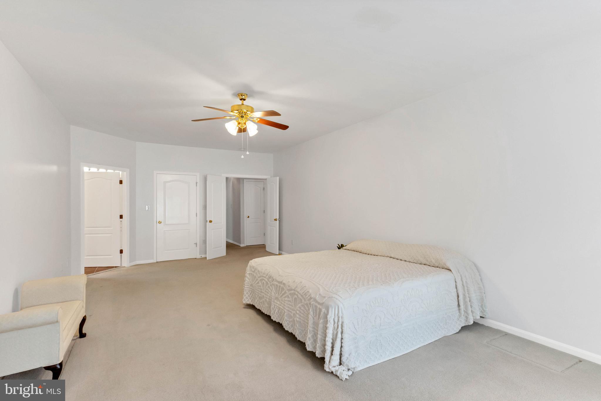 24872 Rivers Edge Road Millsboro, DE 19966 - Photo 28 of 80 a bedroom with a bed and a chandelier