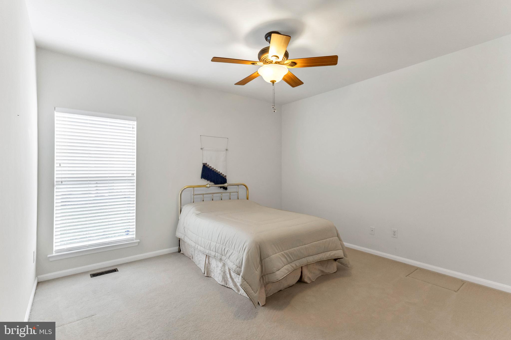 24872 Rivers Edge Road Millsboro, DE 19966 - Photo 37 of 80 a bedroom with a bed and a ceiling fan
