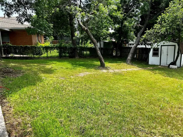 a view of a backyard with a garden and entertaining space