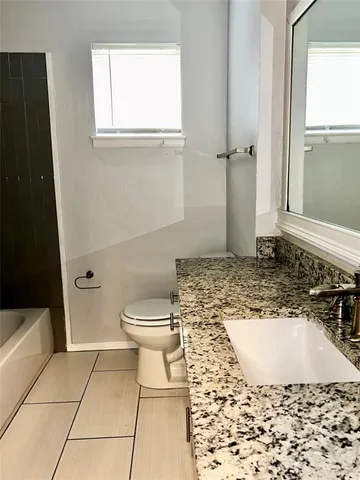 a bathroom with a toilet and a window