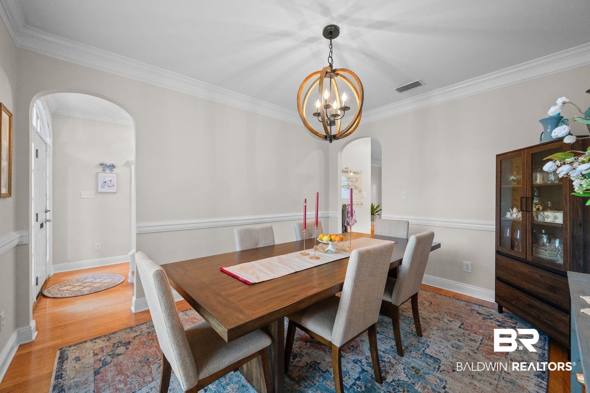 1825 Spring Hill Avenue Mobile, AL 36607 - Photo 7 of 43 Dining area featuring arched walkways, crown molding, wood finished floors, and a chandelier