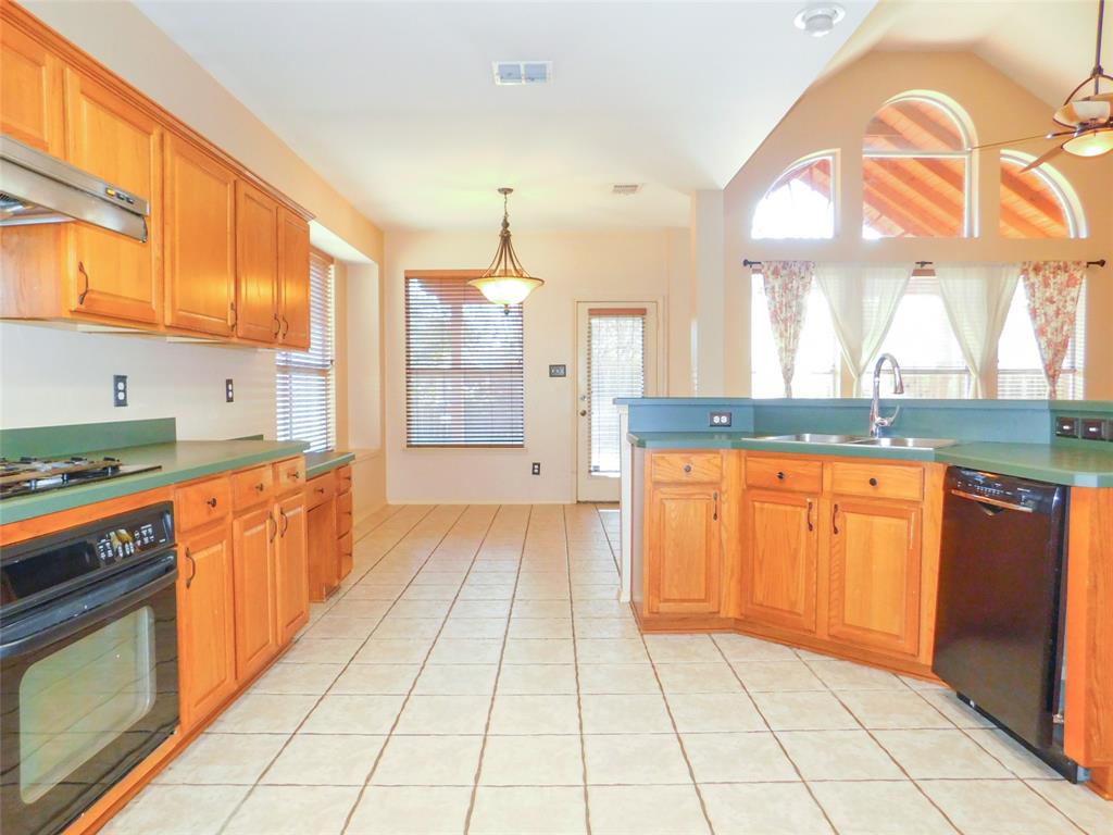 2724 Hereford Road Denton, TX 76210 - Photo 13 of 34 a large kitchen with granite countertop a stove a sink and a refrigerator