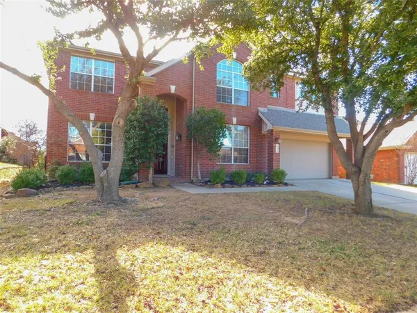 a view of a house with a tree in front of it