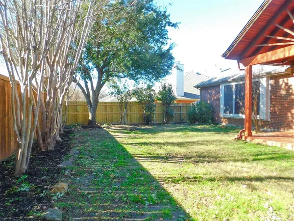 a view of a backyard with a garden and entertaining space