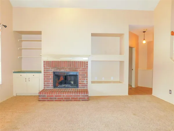 a view of a livingroom with a fireplace and a window