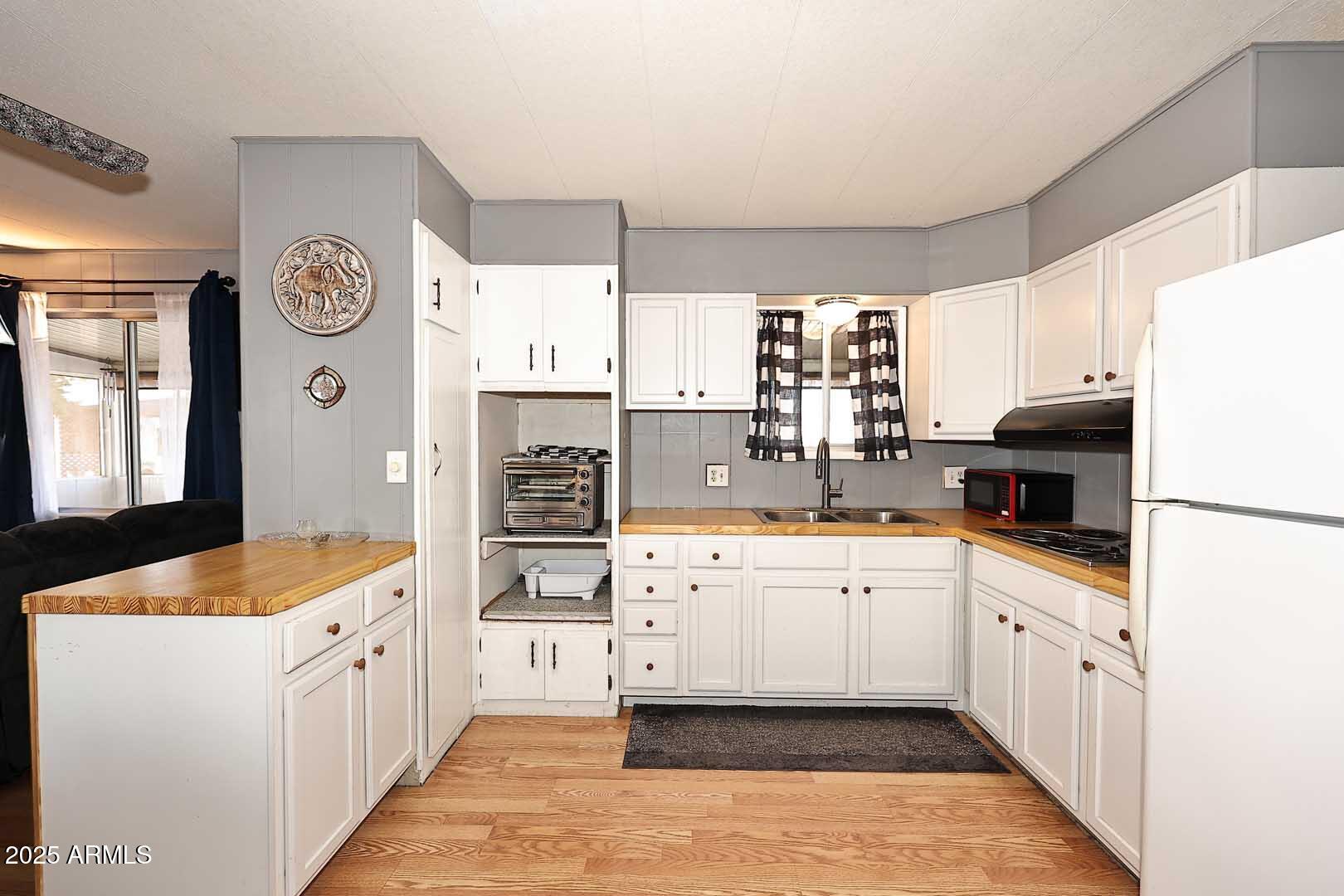 5201 West Camelback Road, Unit 243 Phoenix, AZ 85031 - Photo 6 of 27 a kitchen with white cabinets and white appliances