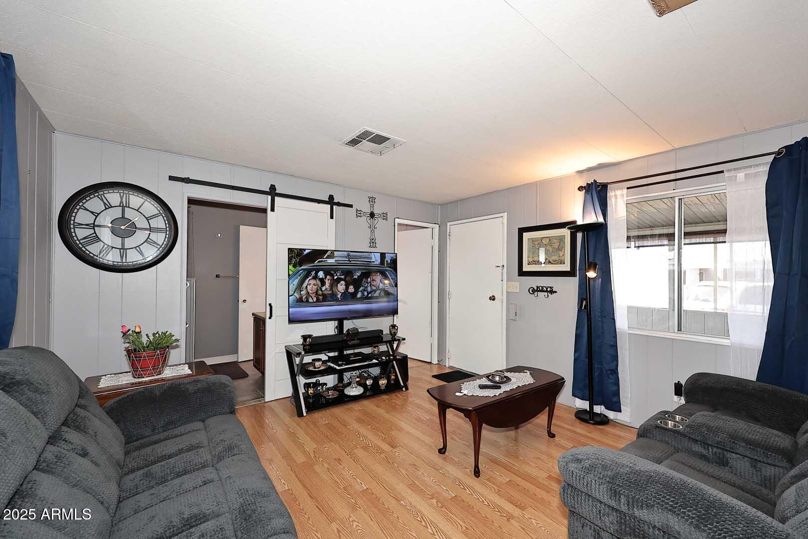 5201 West Camelback Road, Unit 243 Phoenix, AZ 85031 - Photo 8 of 27 a living room with furniture a clock on wall and a window