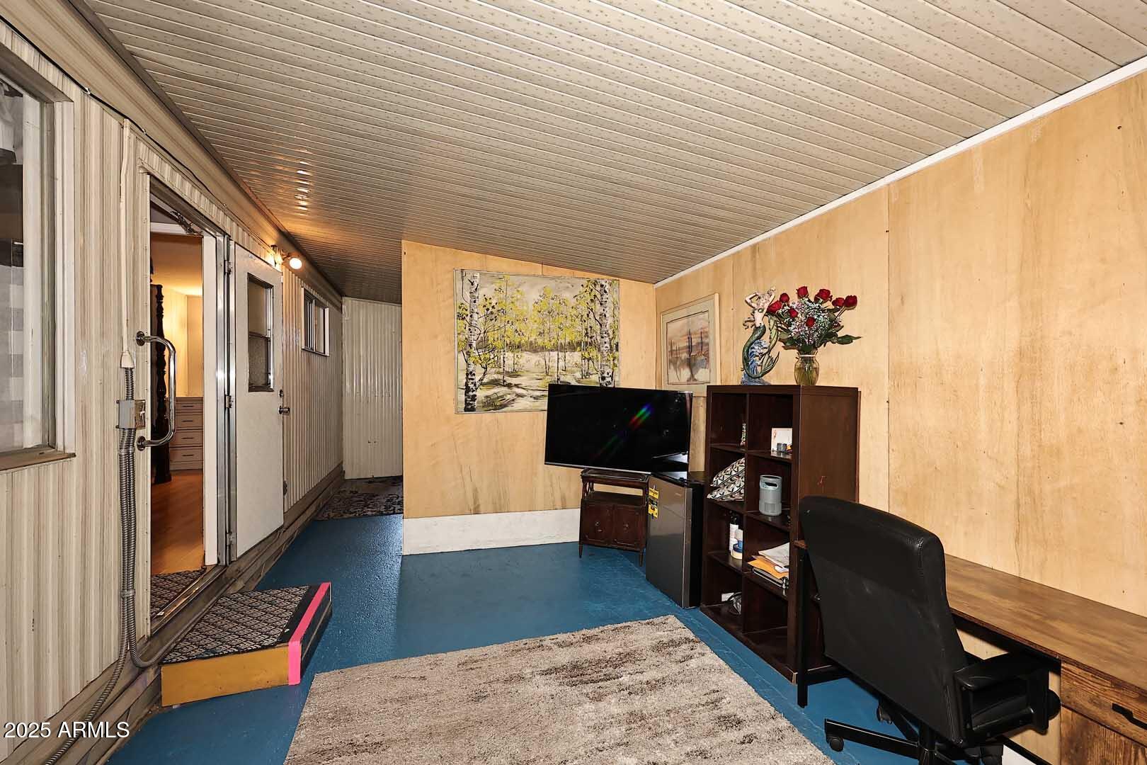 5201 West Camelback Road, Unit 243 Phoenix, AZ 85031 - Photo 10 of 27 a hallway with furniture and a flat screen tv