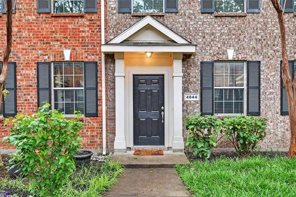 a front view of a house with a yard and plants