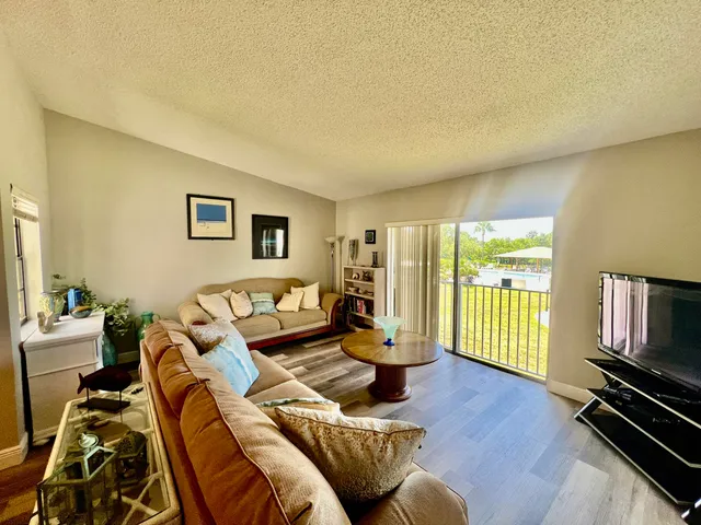 a living room with furniture a flat screen tv and a window