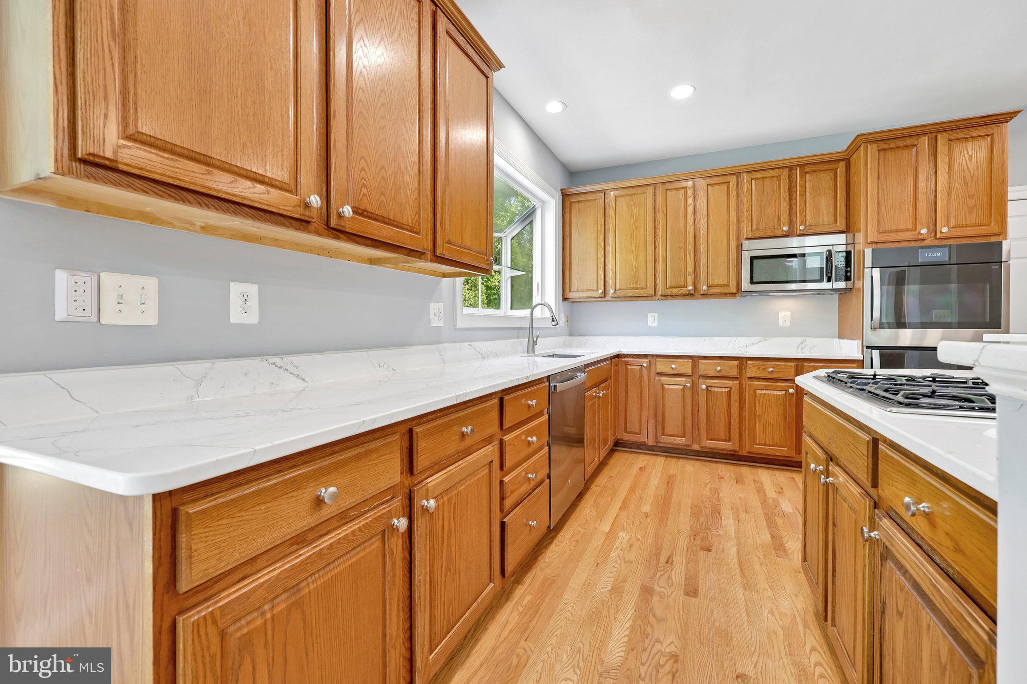 3519 Katrina Court Triangle, VA 22172 - Photo 29 of 101 a kitchen with granite countertop wooden cabinets and white appliances