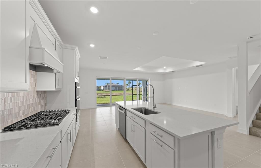 12404 Basalt Lane Alva, FL 33920 - Photo 23 of 50 a kitchen with stainless steel appliances a sink a stove top oven a counter space and cabinets