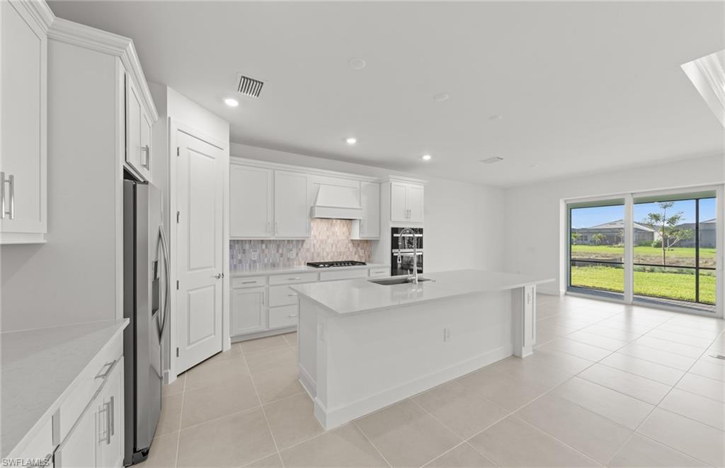 12404 Basalt Lane Alva, FL 33920 - Photo 25 of 50 a kitchen with stainless steel appliances a sink stove and refrigerator