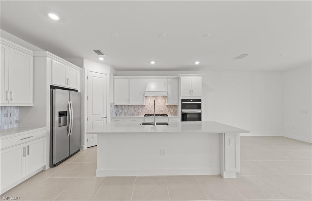 12404 Basalt Lane Alva, FL 33920 - Photo 27 of 50 a large white kitchen with stainless steel appliances