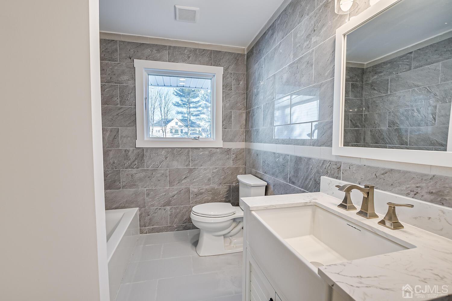 12 Utica Road Edison, NJ 08820 - Photo 42 of 52 a bathroom with a granite countertop sink a toilet and a mirror