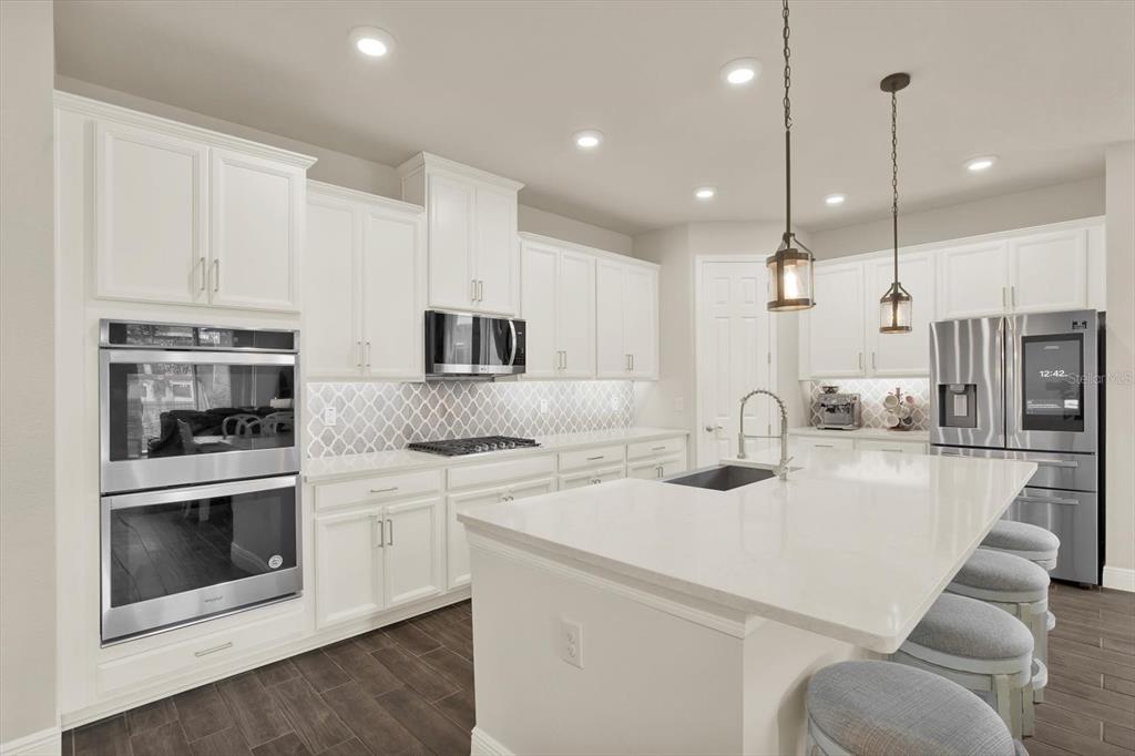 6003 Milestone Drive Apollo Beach, FL 33572 - Photo 11 of 50 a kitchen with stainless steel appliances granite countertop a sink a stove and a refrigerator