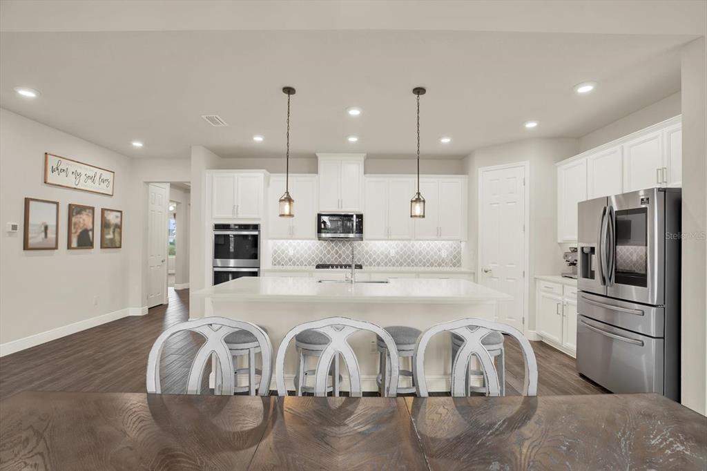 6003 Milestone Drive Apollo Beach, FL 33572 - Photo 14 of 50 a kitchen with stainless steel appliances granite countertop a sink refrigerator and cabinets