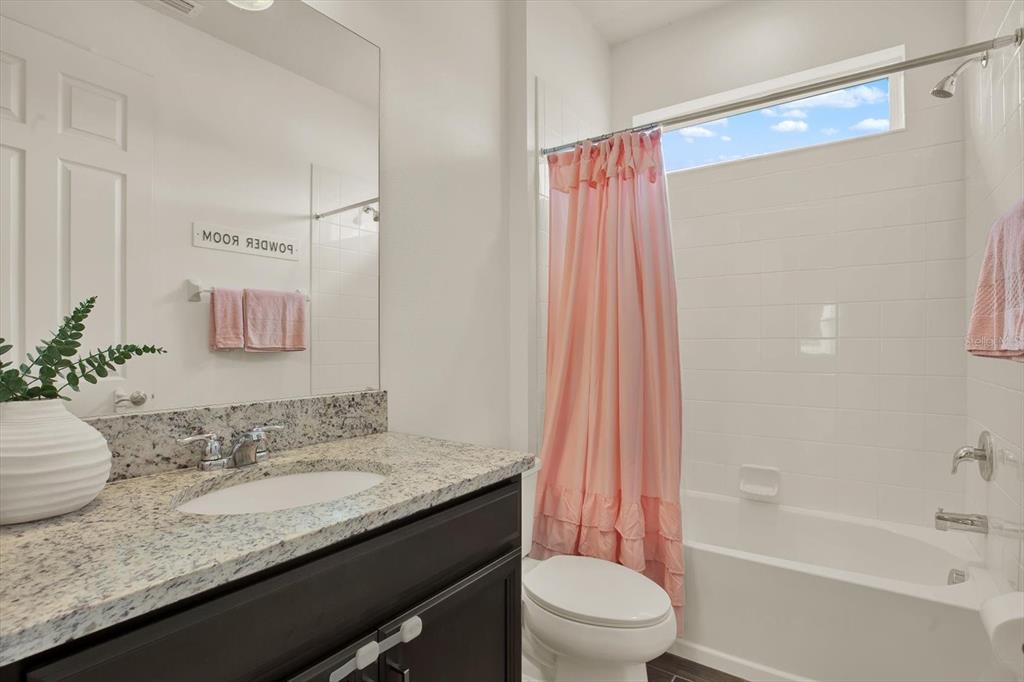 6003 Milestone Drive Apollo Beach, FL 33572 - Photo 22 of 50 a bathroom with a granite countertop sink a toilet and shower