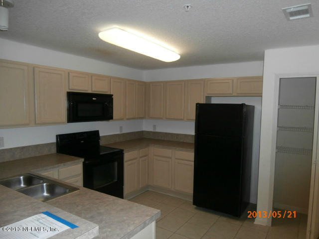 7920 Merrill Road, Unit 310 Jacksonville, FL 32277 - Photo 2 of 7 a kitchen with a refrigerator and a sink
