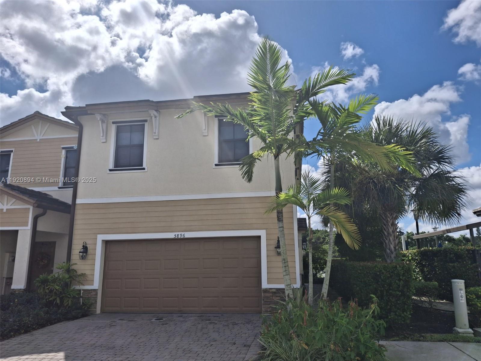 5896 Mustang Manor Davie, FL 33314 - Photo 2 of 14 a front view of a house with a garden