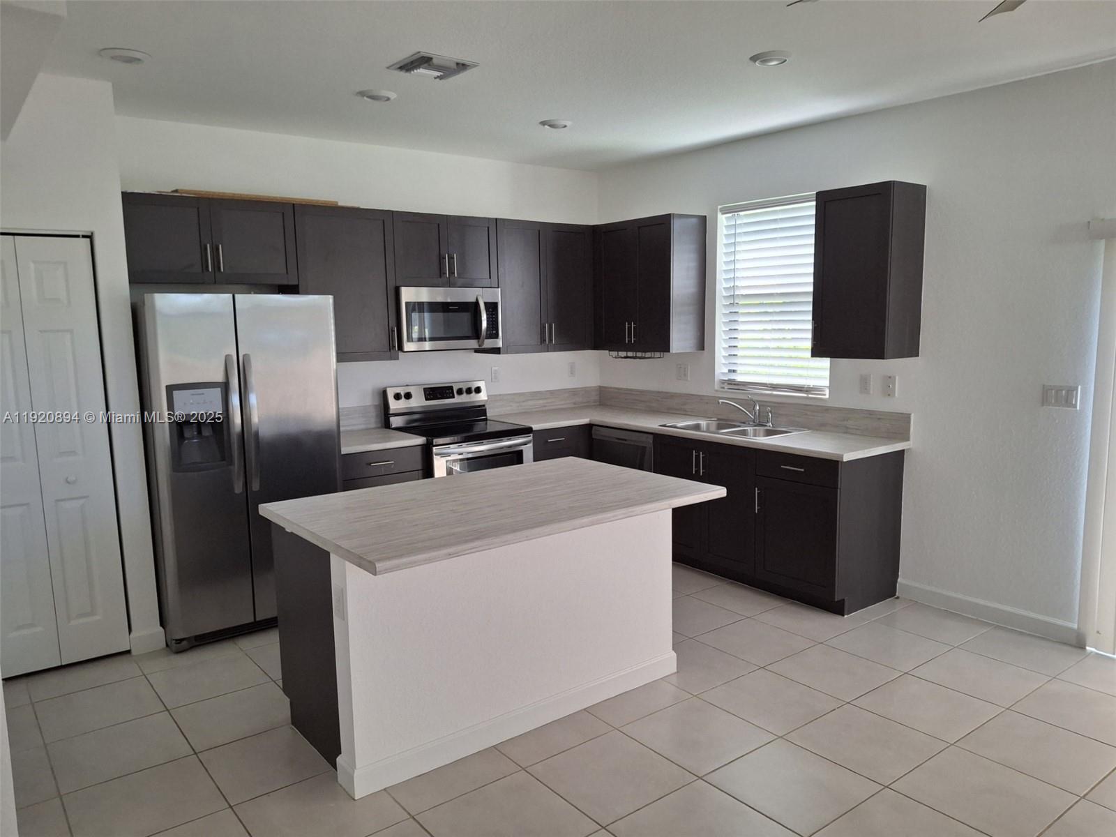 5896 Mustang Manor Davie, FL 33314 - Photo 8 of 14 a kitchen with stainless steel appliances granite countertop a sink stove and refrigerator