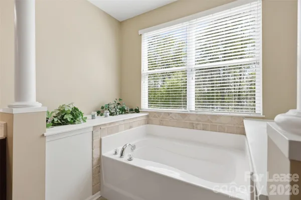 a bathroom with bathtub and window