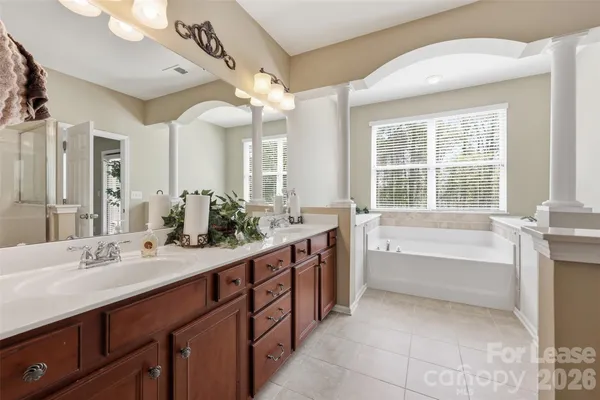 a spacious bathroom with a large tub sink and mirror