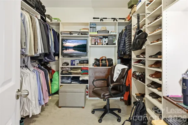 a view of walk in closet with clothes and shoes