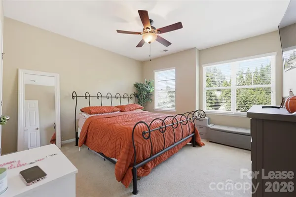 a bedroom with a bed and a large window