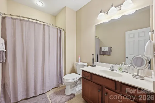 a bathroom with a double vanity sink toilet and a mirror