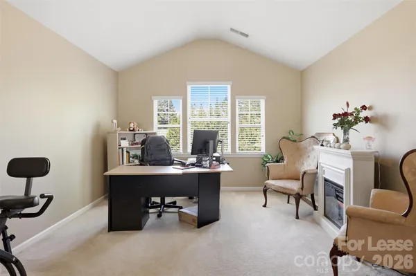 a view of a workspace with furniture and a window