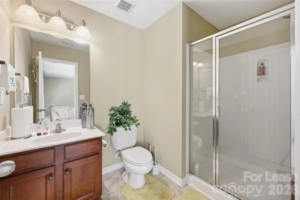 a bathroom with a shower sink vanity mirror and toilet