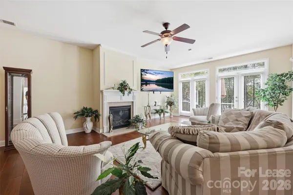 a living room with furniture a fireplace and a chandelier